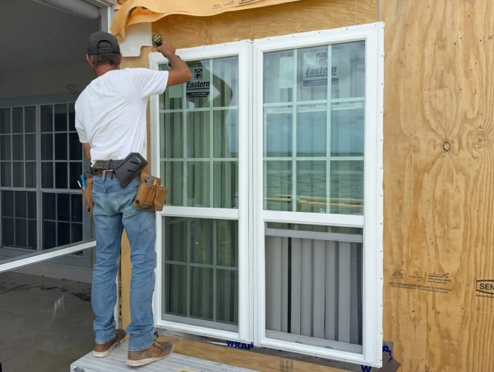 Contractor installing a new window on a Florida home exterior